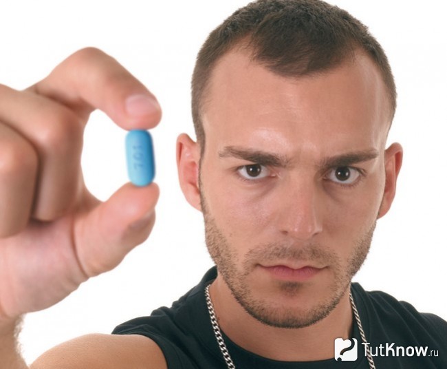 Спортсмен держит таблетку