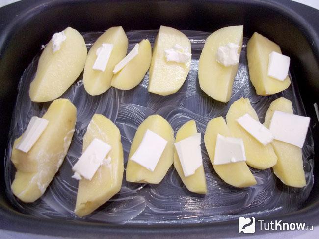 Картошка выложена на противень, добавлено масло и отправлена в духовку