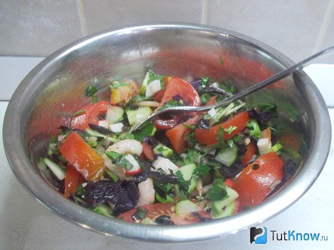 Готовый салат с помидорами, креветками и крабовыми палочками