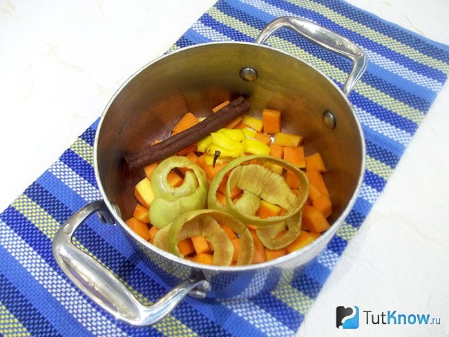 К тыкве в кастрюлю добавлены палочка корицы, шкурка яблок и лимона