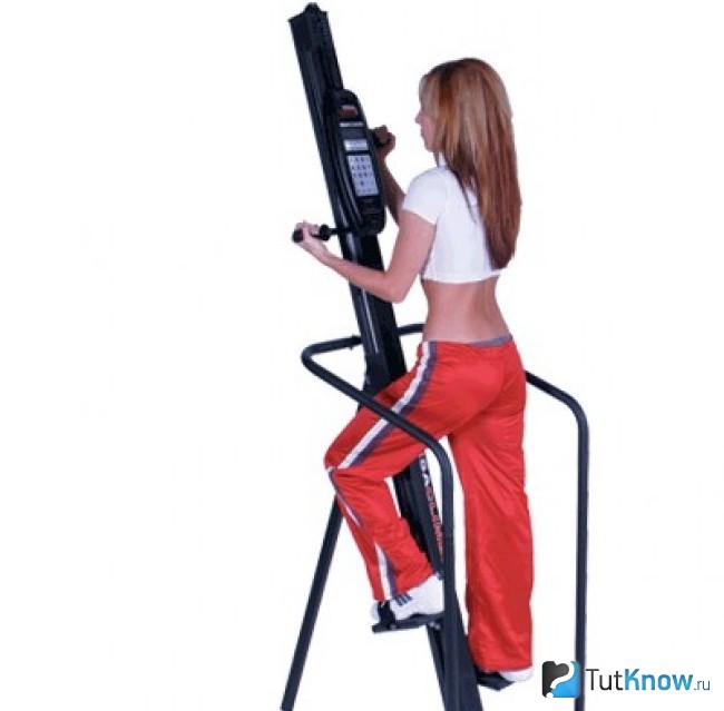 Девушка занимается на тренажере VersaClimber