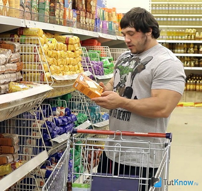 Культурист выбирает продукты в супермаркете