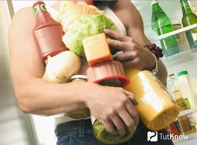 Спортсмен держит продукты в руках