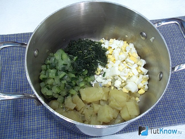 Картофель, яйца, огурцы и лук опущены в кастрюлю