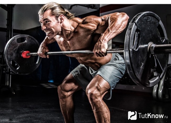 Атлет выполняет взрывное движение в силовой тренировке с помощью штанги