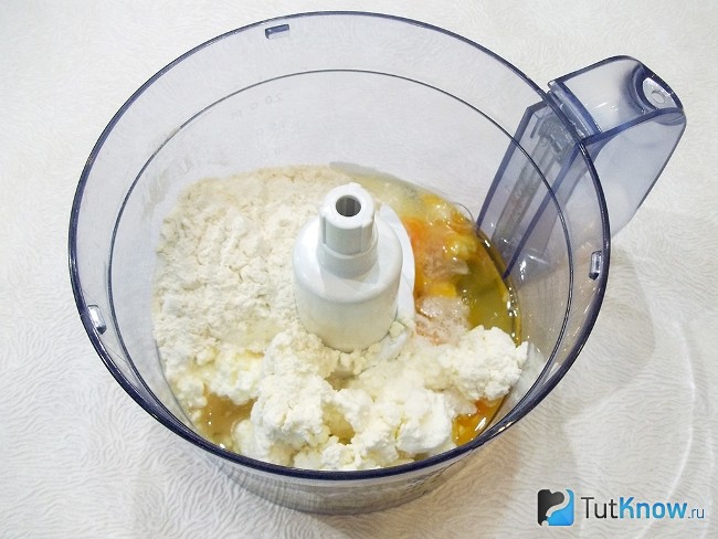Творог, мука, яйца и соль опушены в кухонный комбайн для замеса теста