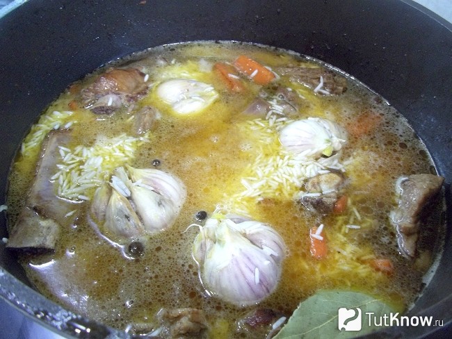 К мясу добавлены головки чеснока, рис и все продукты залиты питьевой водой