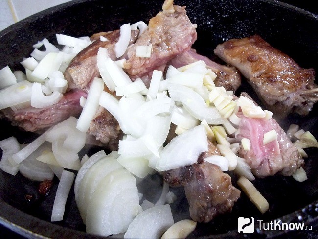 Репчатый лук и чеснок добавлены в сковороду к мясу