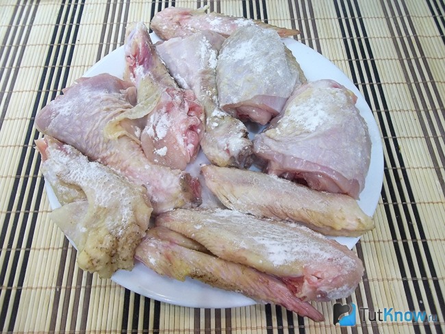 Курица нарезана кусочками, вымыта и присыпана мукой