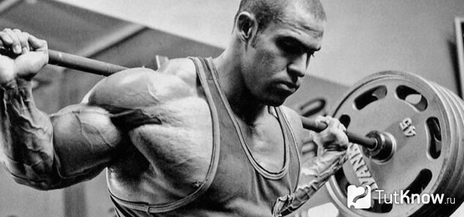 Спортсмен тренируется со штангой