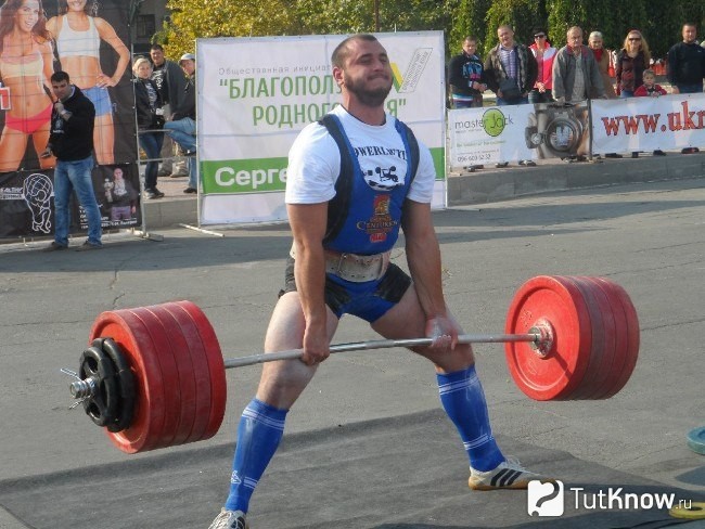 Спортсмен выполняет становую тягу на соревнованиях