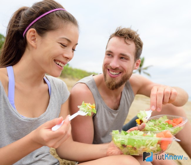 Женщина и мужчина едят салат