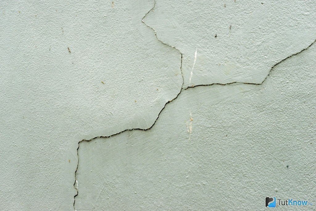 На стене появились трещины. Трещины на штукатурке. Треснувшая штукатурка. Дефекты стен. Потрескавшаяся штукатурка.