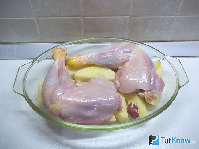 Куриные бедра вымыты и выложены сверху картофеля