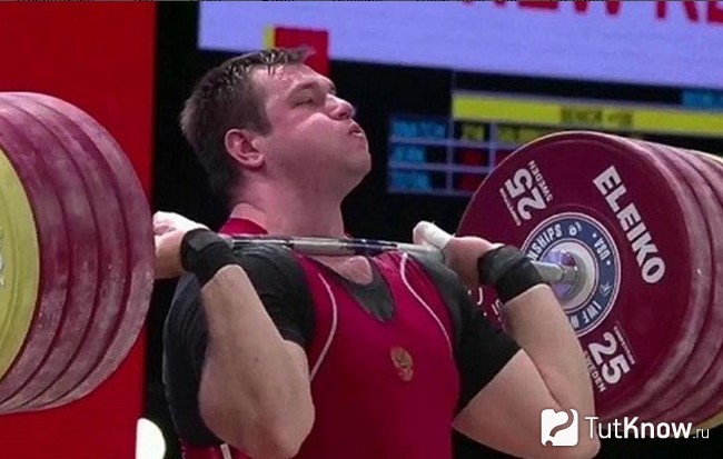 Спортсмен выполняет рывок и толчок штанги