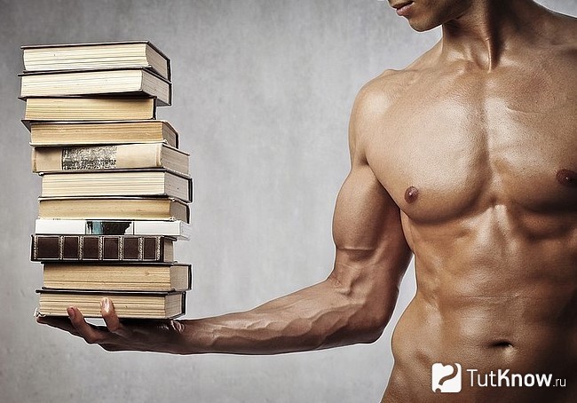 Спортсмен держит гору книг одной рукой