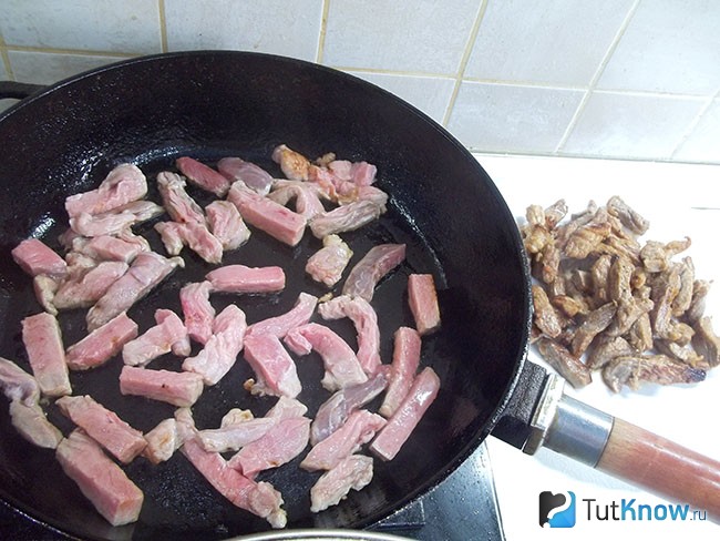 Мясо нарезано кусочками и жарится на сковороде