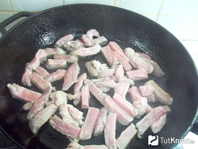 Мясо нарезано кусочками и жарится на сковороде