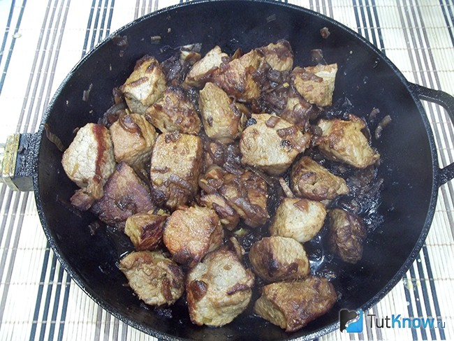 Мясо и лук жарятся на сковороде
