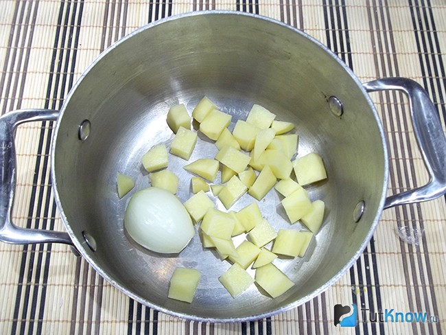 Нарезанный картофель с луковице опущены в варочную кастрюлю