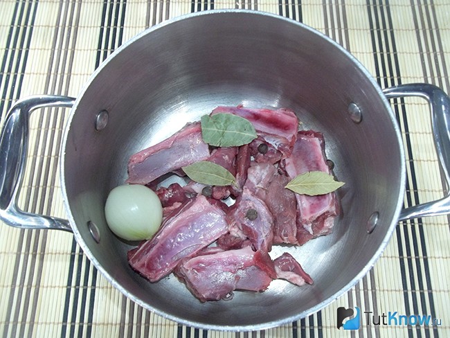 Мясо, луковица и специи опущены в кастрюлю