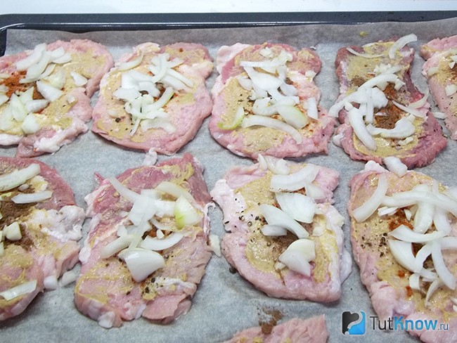 На мясо выложен лук с чесноком