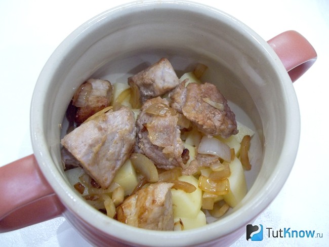 В горшочки разложен картофель и мясо с луком