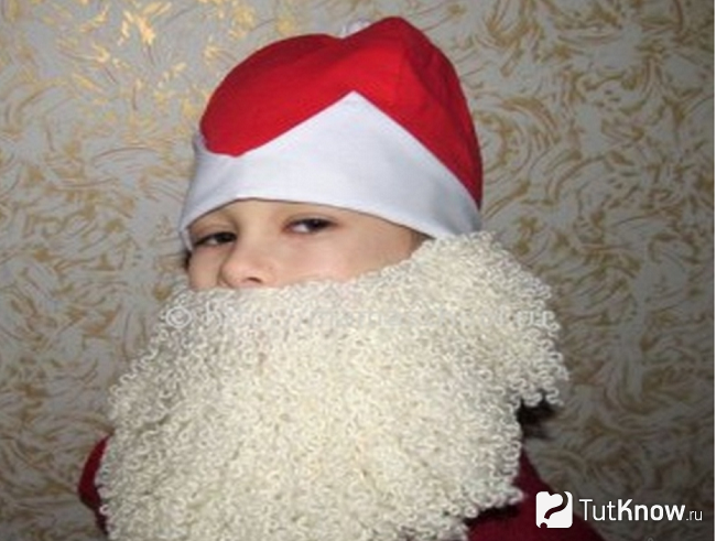Ребёнок в шапке и с бородой Деда Мороза