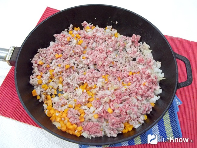 Мясо, морковь, лук и чеснок жарятся в сковороде