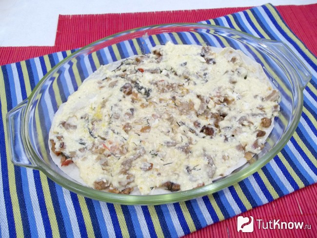 Мясо смазано соусом и присыпано сыром