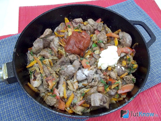 К продуктам в сковороду добавлены специи, томат и сметана