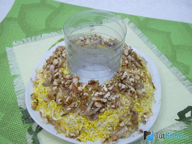 На продукты выложен жареный лук и грецкие орехи