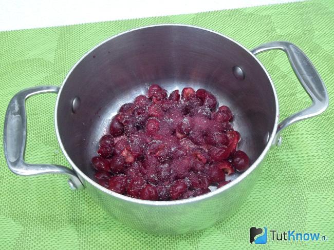 В кастрюлю положены вишни и сахар