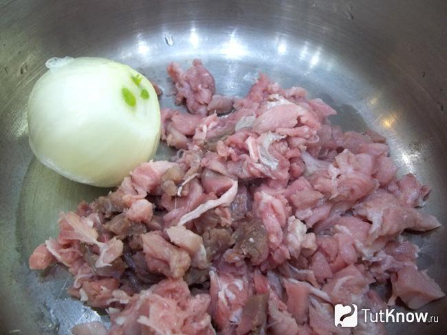 Нарезанное мясо с луковицей сложены в кастрюлю