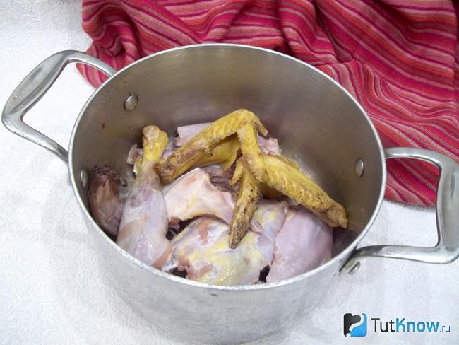 Курица нарезана и опущена в кастрюлю