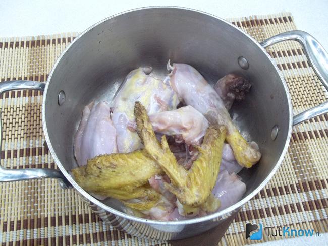Курица нарезана и сложена в кастрюлю