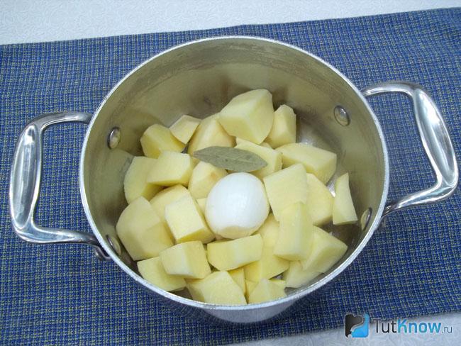 Картофель очищен, нарезан и сложен в кастрюлю с луком