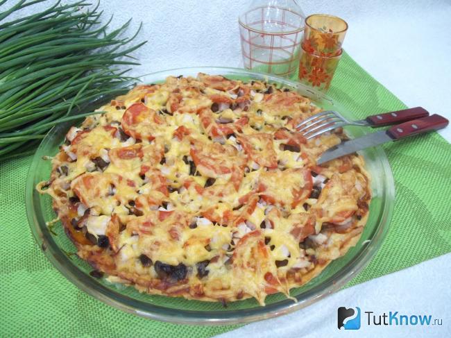Готовая пицца с ветчиной и помидорами
