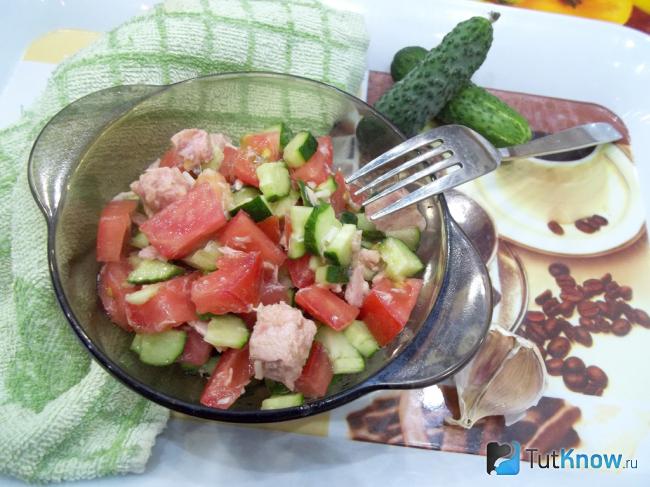 Готовый салат из помидоров, огурцов и рыбы
