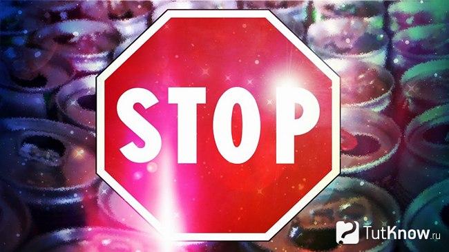 Знак Stop на фоне банок с энергетическими напитками
