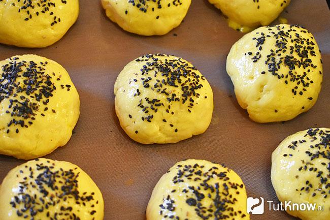 Булочки перед выпеканием посыпаны черным кунжутом