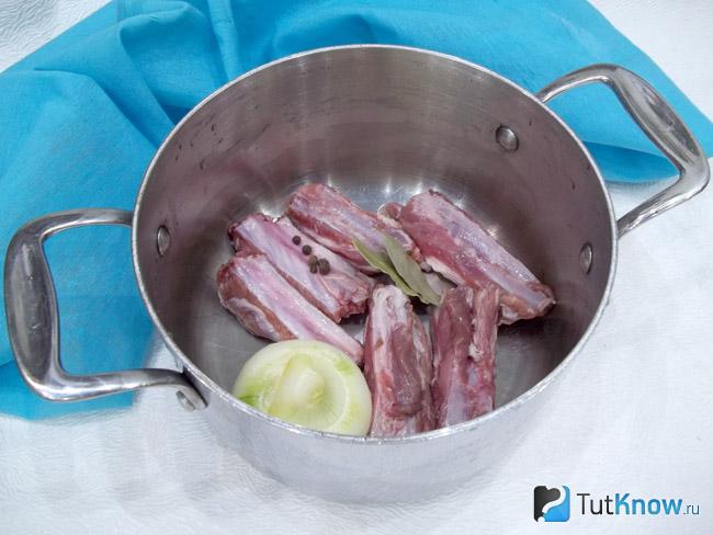 Мясо, лук и пряности опущены в кастрюлю