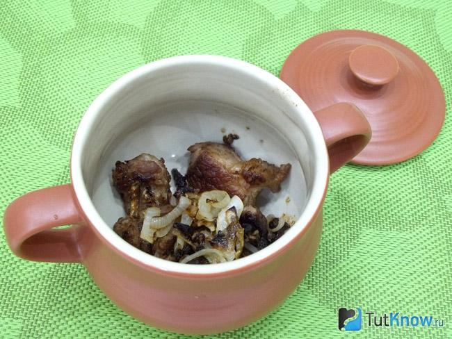 Мясо с луком сложены в горшочек