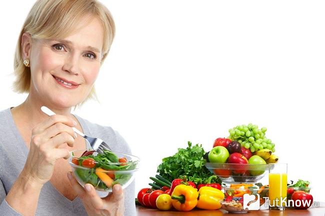 Возрастная женщина кушает салат