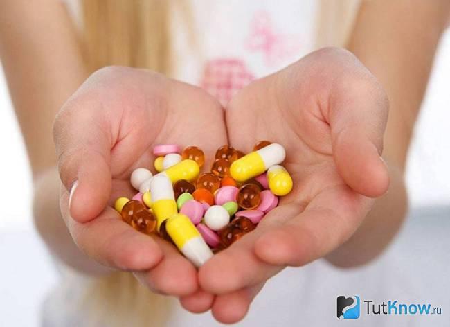 Разноцветные медицинские препараты в руках у девушки