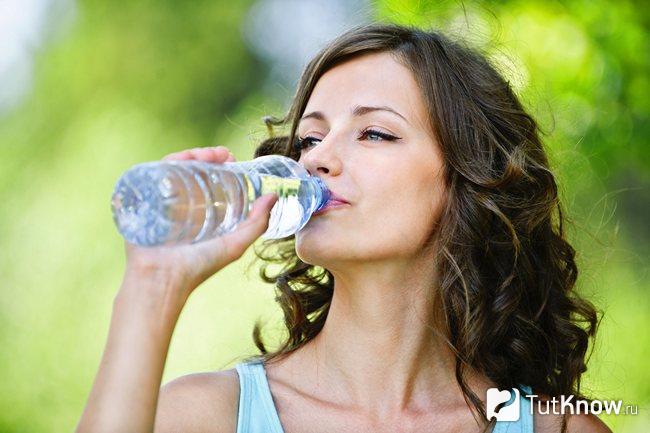 Девушка пьёт воду из бутылки