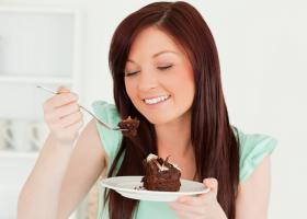 Девушка кушает шоколадный торт