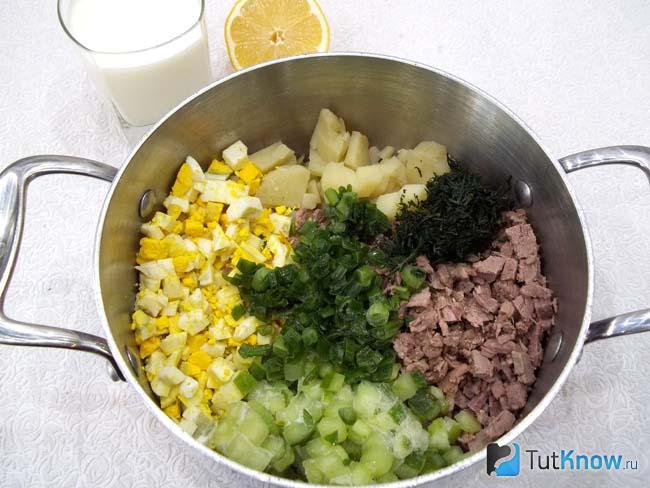 К продуктам добавлен нарезанный огурец и зелень
