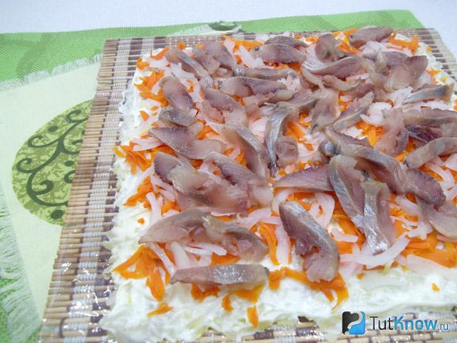 Сверху выложена селедка нарезанная кусочками
