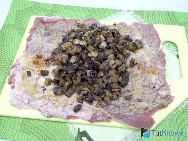 На мясо выложены жареные грибы